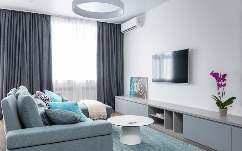 Technicien installant une climatisation gainable dans les combles d'une maison